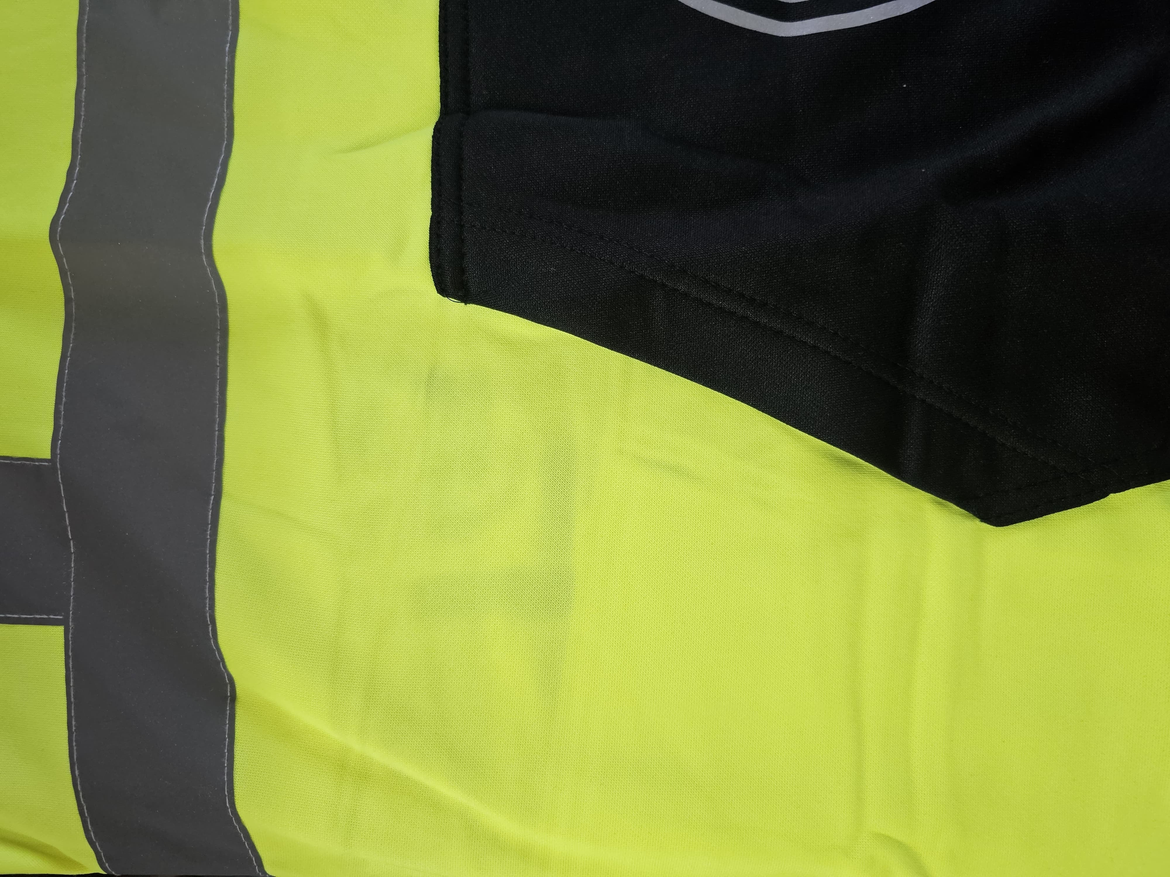 Premium Class 3 Hi-Vis Branded Hoodie close-up showing fluorescent yellow fabric, black pocket edge and silver reflective tape