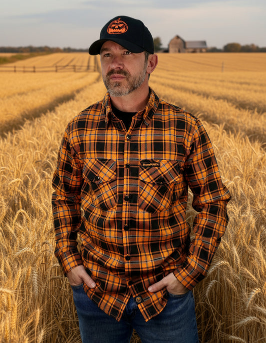 Man wearing a black and orange plaid shirt with a matching cap on a white background