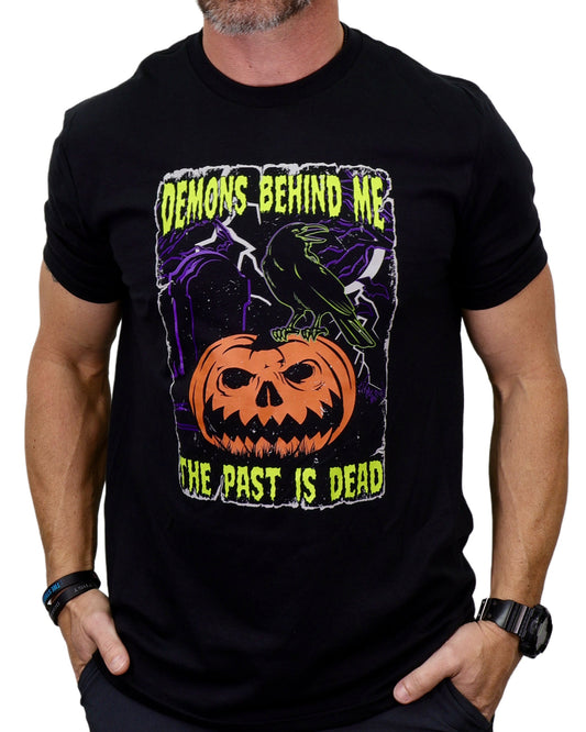 Black t-shirt with Halloween-themed design featuring a pumpkin and text, worn by a person.
