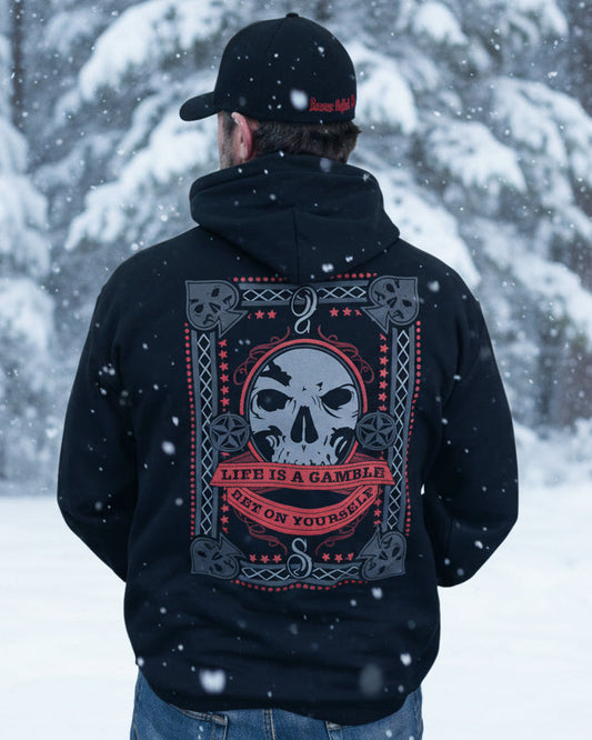 Person wearing a black hoodie with a skull design and text on the back, standing against a white background.