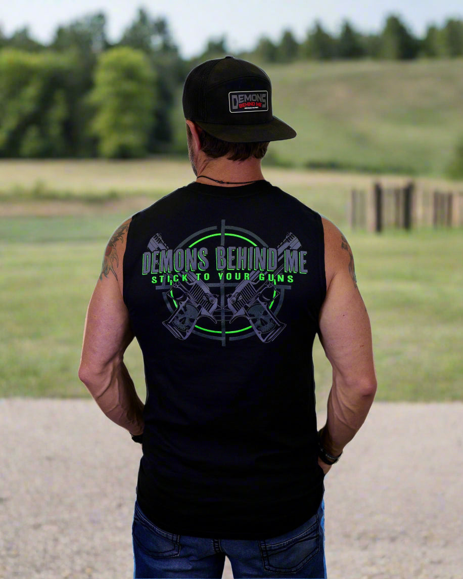 Person wearing a black sleeveless shirt with text and graphics, standing against a white background