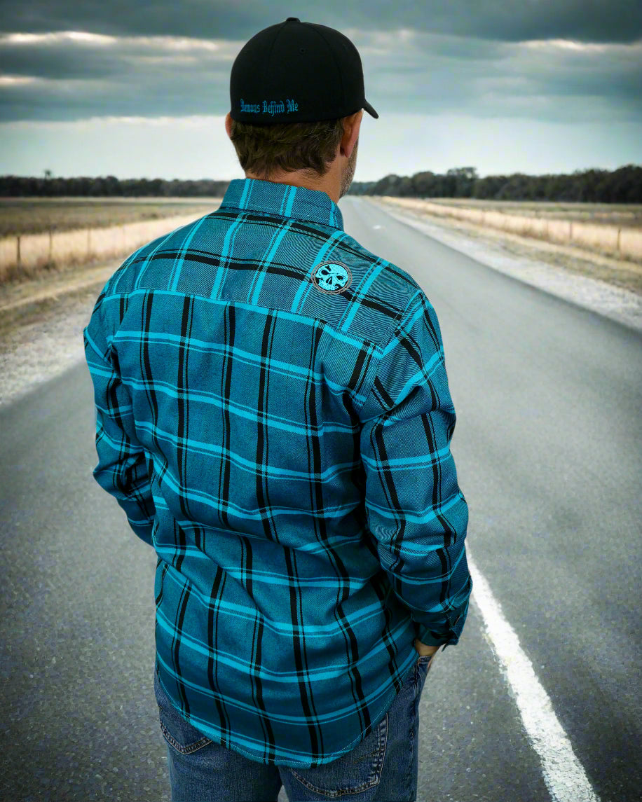 Person wearing a blue plaid shirt with a logo on the back, standing against a white background