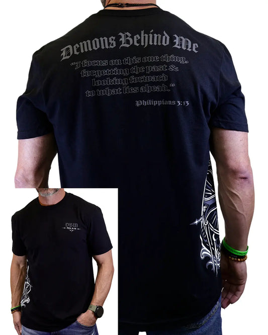 Black t-shirt with text and design on the back, worn by a person. Philippians 3:13.