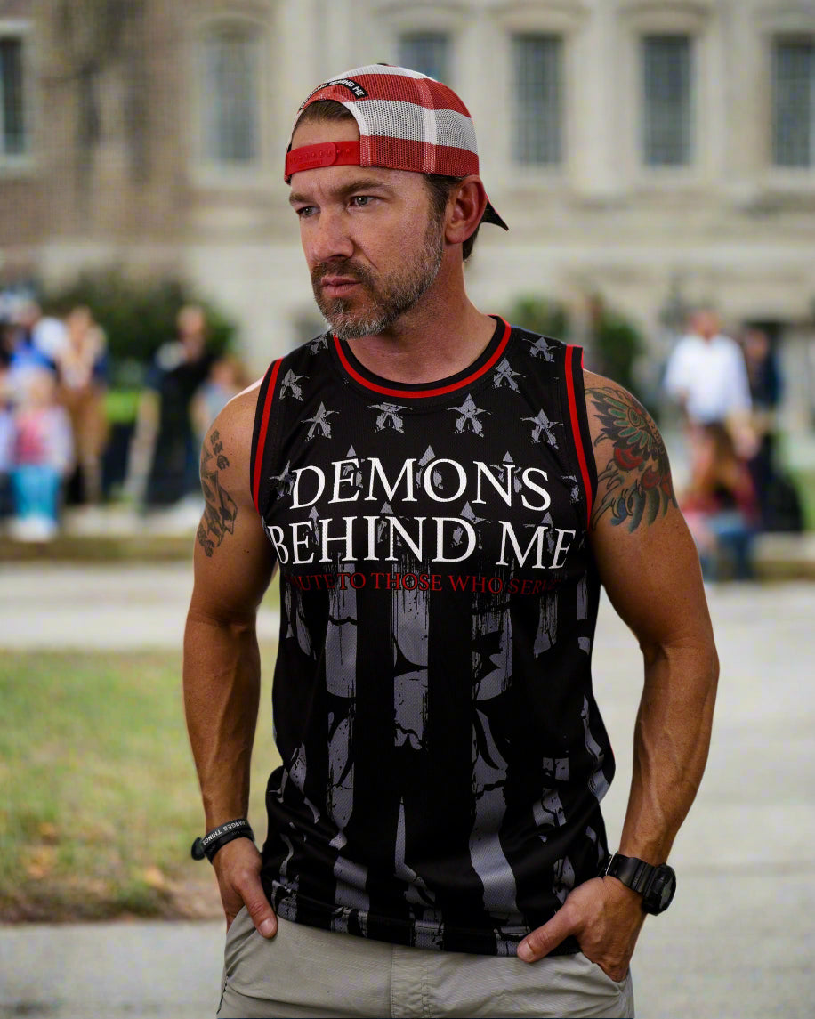 Man wearing a sleeveless shirt with 'Demons Behind Me' text and graphics on a white background