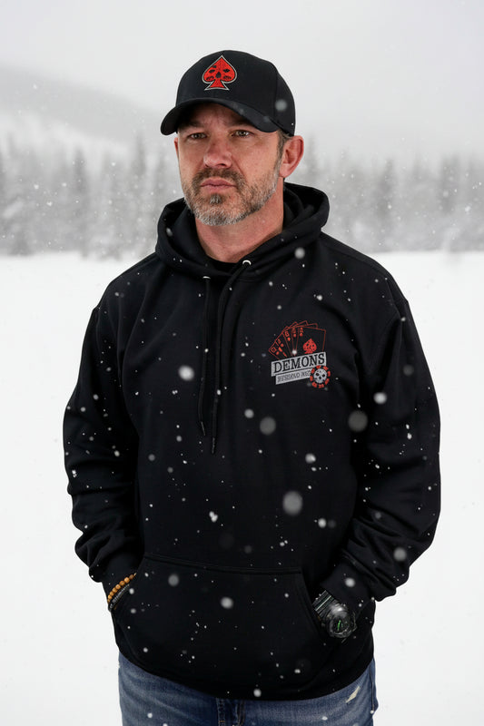 Man wearing a black hoodie with a logo and a matching cap on a white background