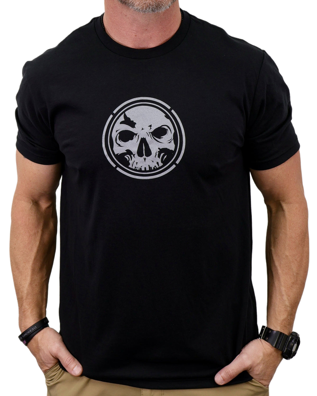 Black t-shirt with a skull design worn by a person on a white background
