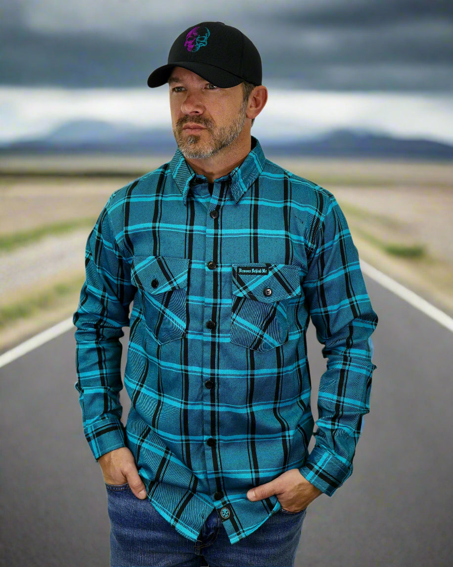 Man wearing a blue plaid shirt and black cap on a white background