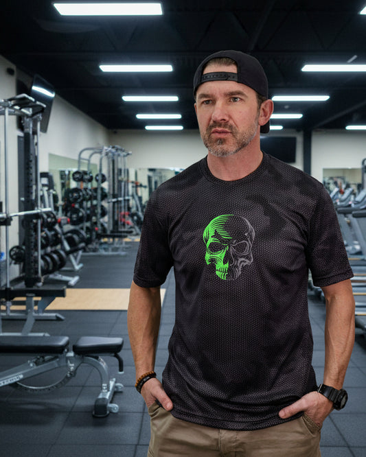 Man wearing a black t-shirt with a green skull design on a white background