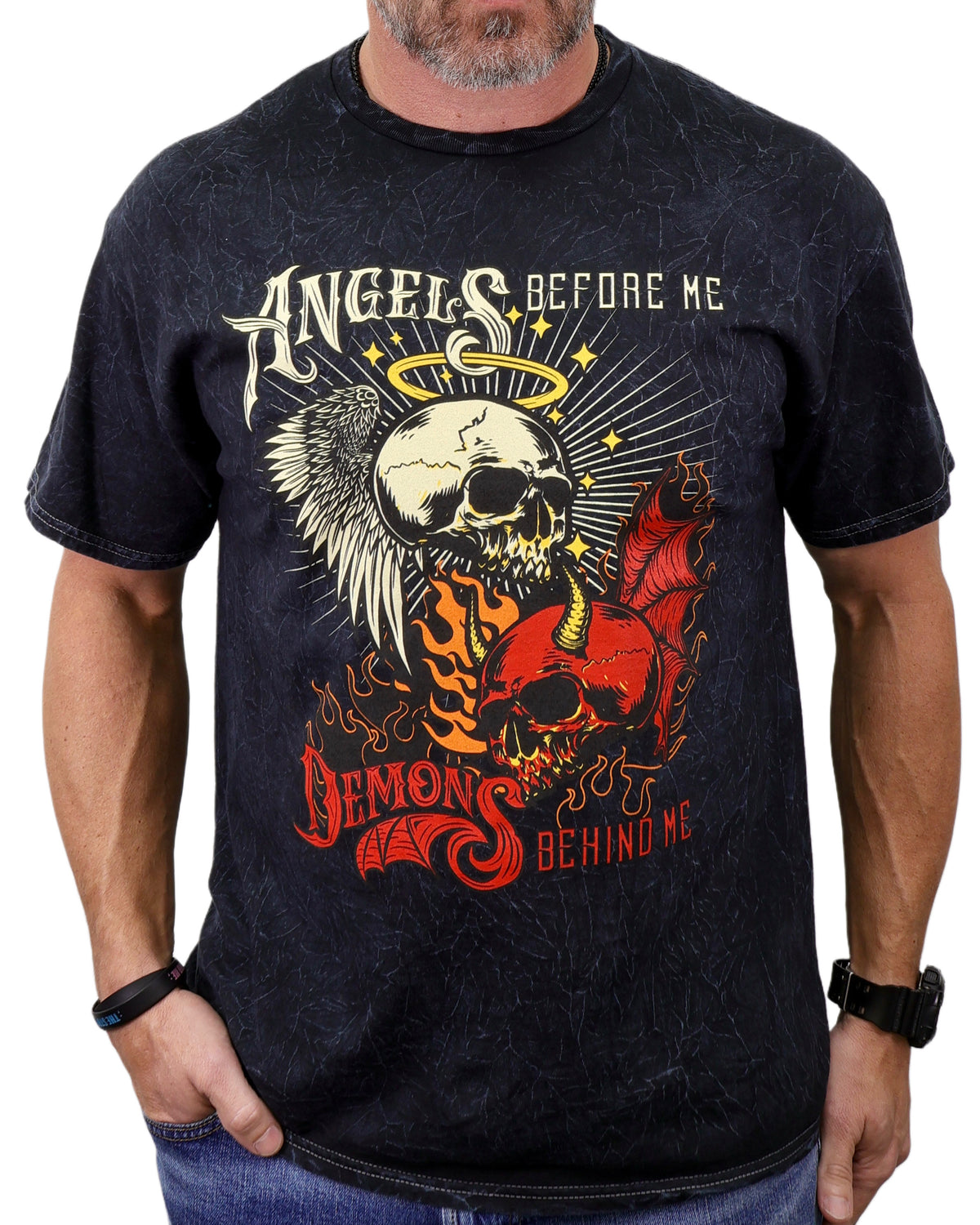 Person wearing a black t-shirt with a graphic design featuring skulls and text.