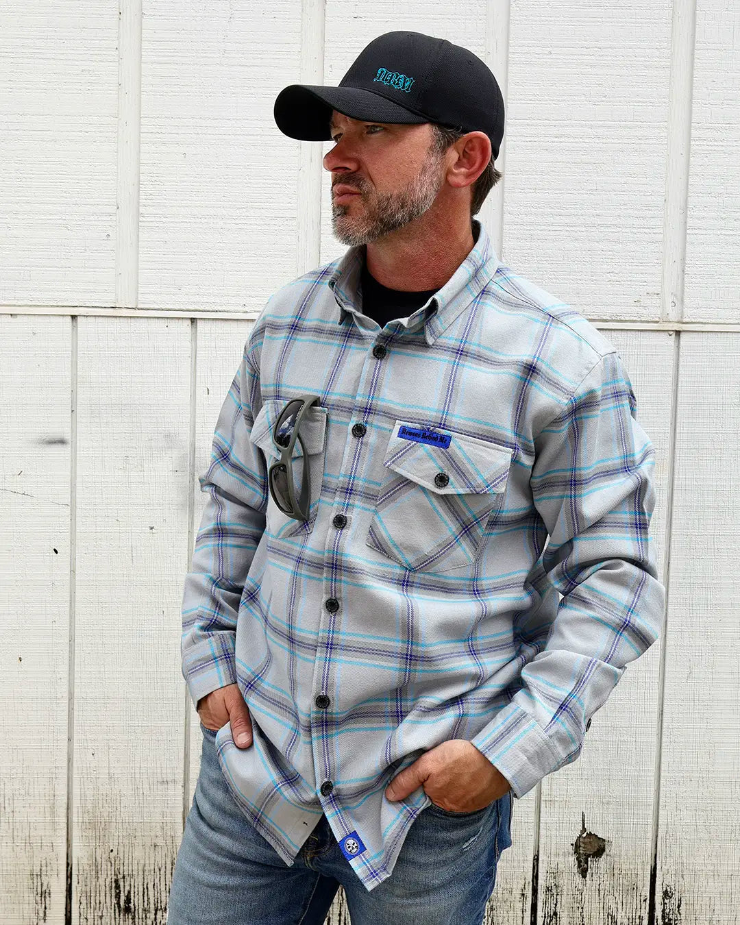 Model wearing the “Blueprint” gray, blue and purple plaid flannel, angled front view
